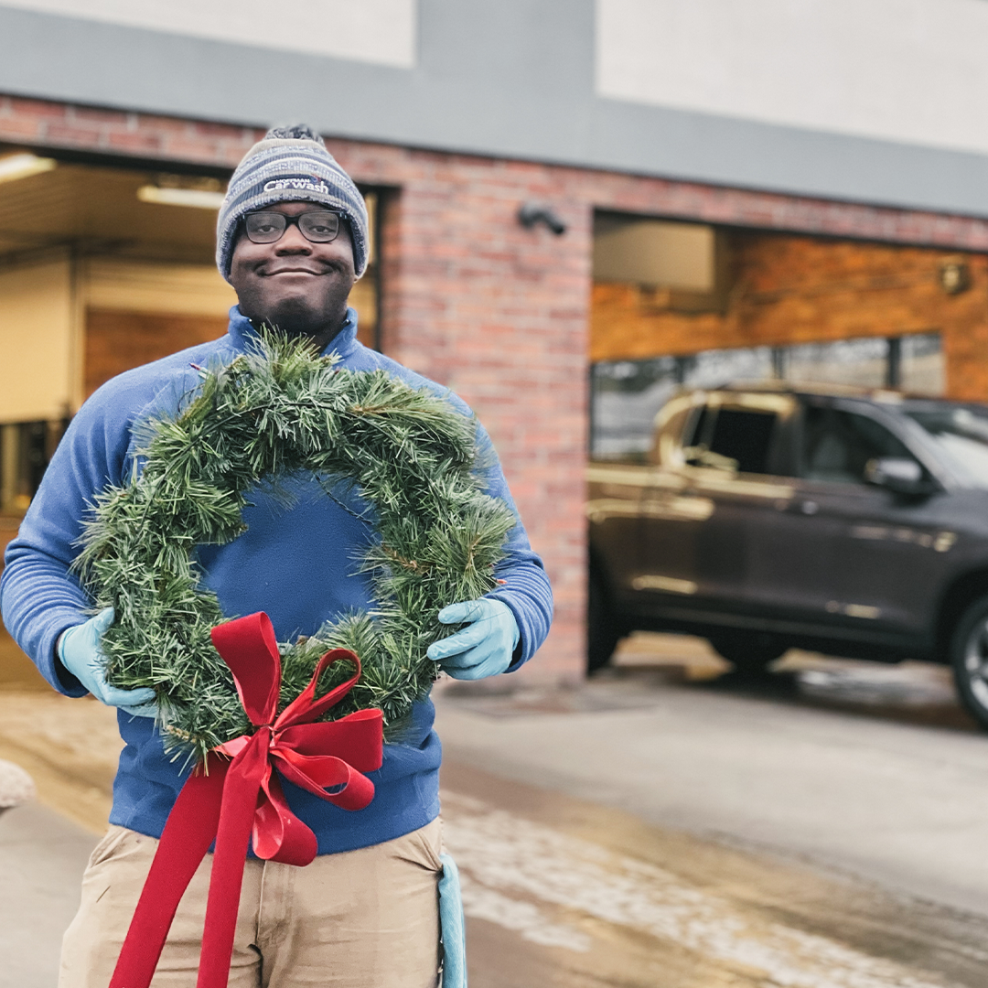 Hoffman employee holding a wreath with a red bow