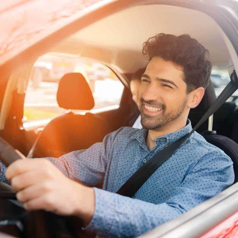Smiling bearded man driving a car
