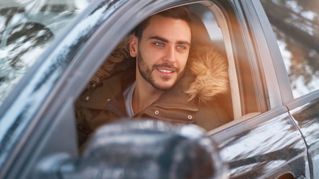 Man about to get his car wash smiling out the drive side window