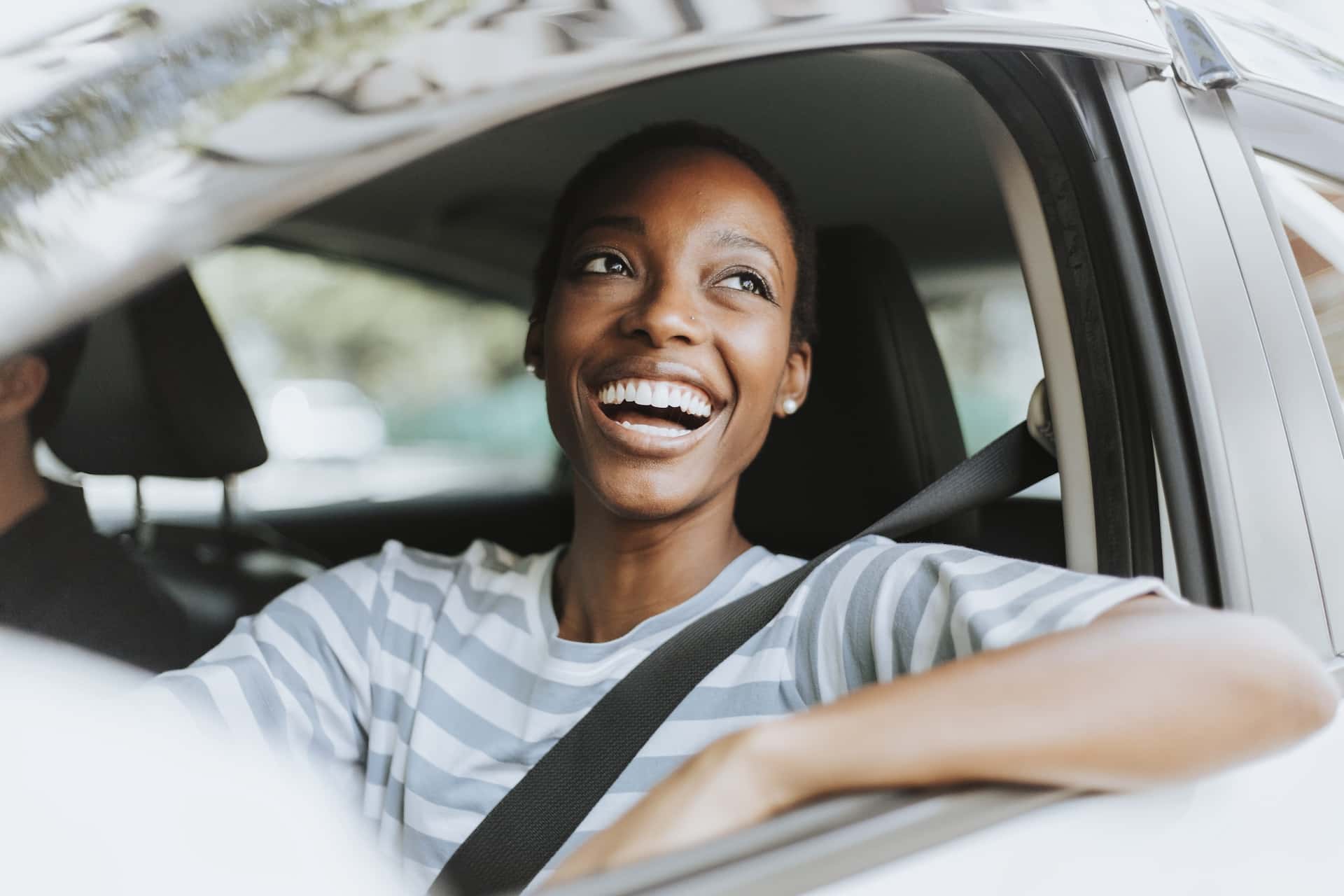 woman smiling and looking out of her car window
