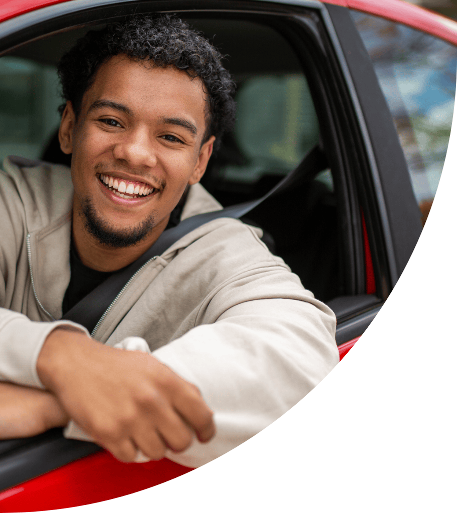 Photo of a smiling man leaning out of his car window